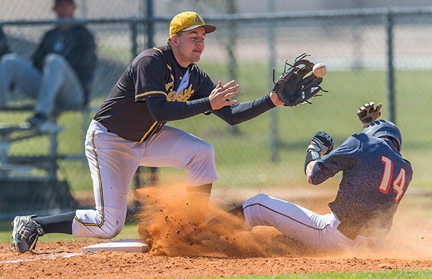 A Spring Woods (Houston) third baseman prepares to catch a throw in front of a sliding Klein Collins (Spring) player.