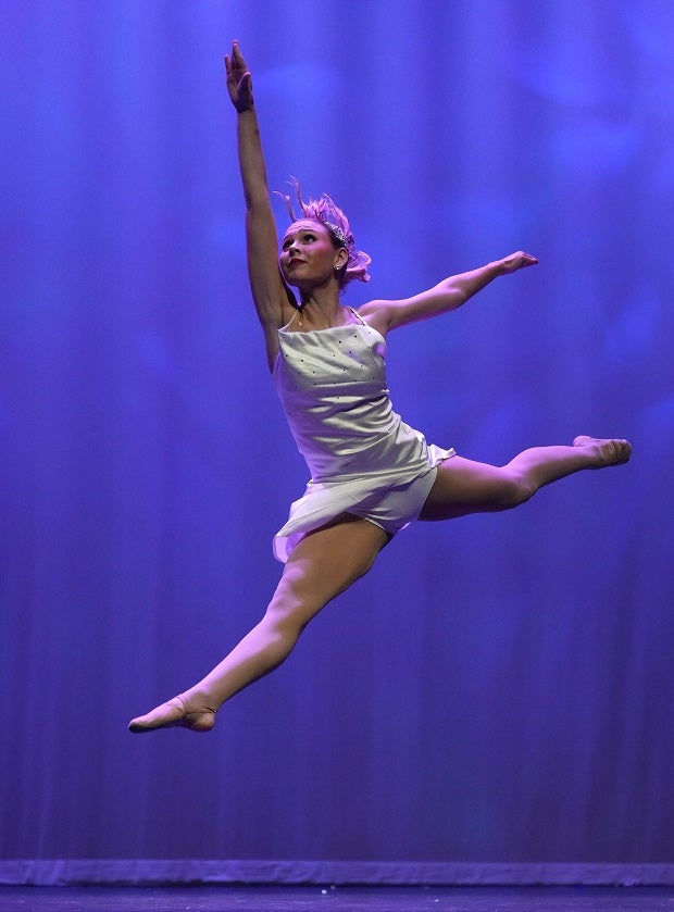 A dancer leaps on stage at the Strutters Showcase in College Station, Texas. (Photo: Charles Hernandez)