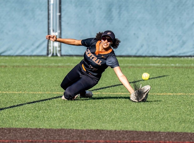 Central outfielder Kamana Powell dives for a catch causing turf pellets to fly up. (Photo: Larry Kauk)