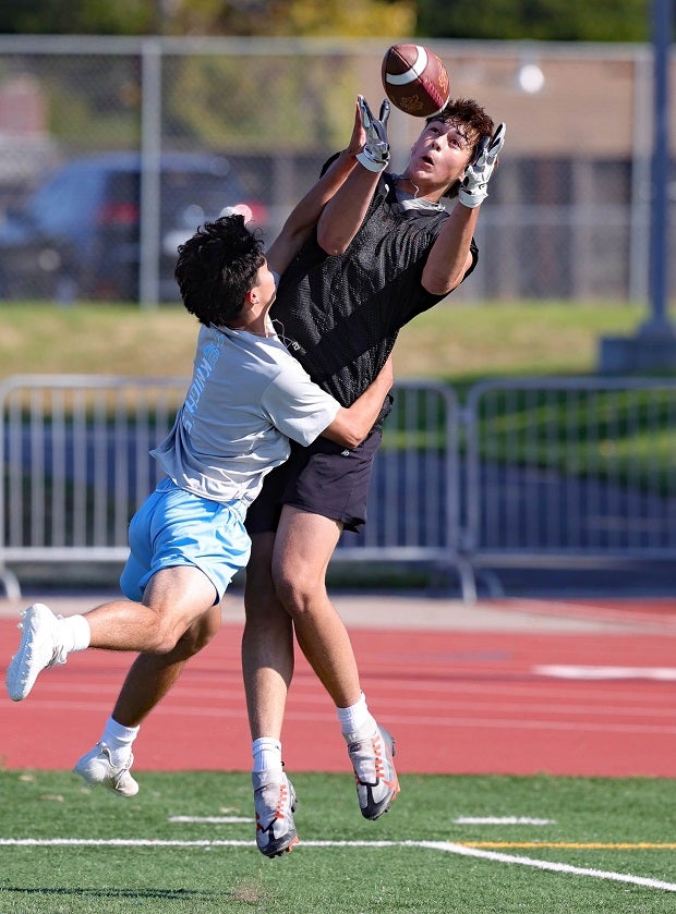 A Menlo-Atherton receiver pulls in a catch over a Hillsdale defender during 7-on-7 competition. (Photo: James Regan)