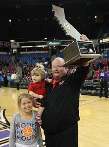 Gary McKnight holds up record ninth
state title trophy.