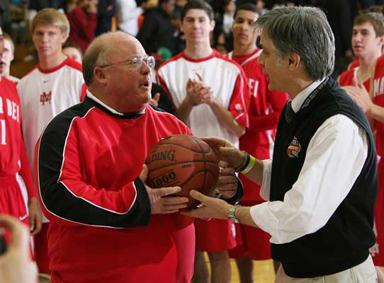 Mater Dei's Gary McKnight accepts the game ball after becoming the winningest boys basketball coach in California history with win No. 844 over DeMatha of Maryland.