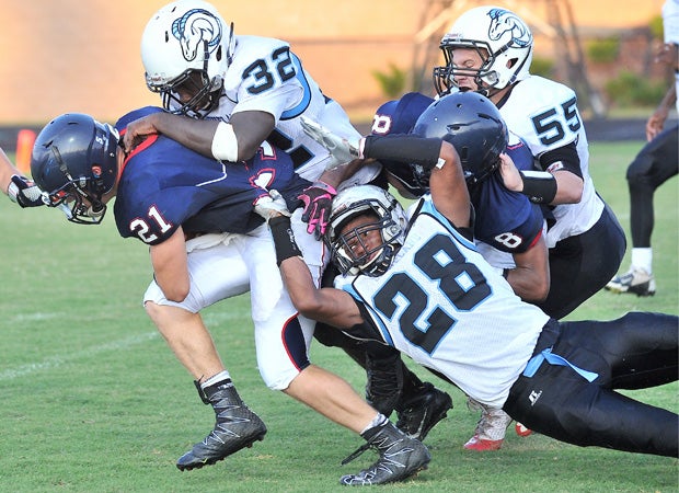 Apex Friendship (N.C.) running back Jacob Kelley drags several Cleveland (N.C.) defenders.  