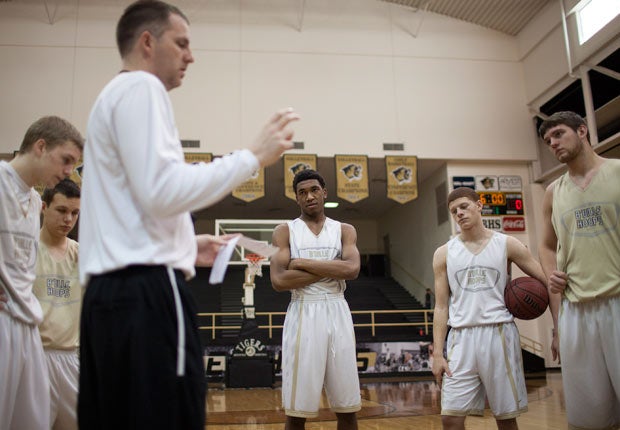 Malik (center) and his teammates listen to head coach Jason McMahan during a recent practice. McMahan has been the man at the helm leading the school's resurgence.