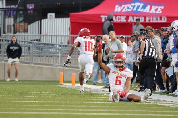 Senior linebacker Jarvon Coles races down the sideline after intercepting his second pass of the game as teammate Devin Sanchez celebrates from the ground. (Photo: Paul Knight)
