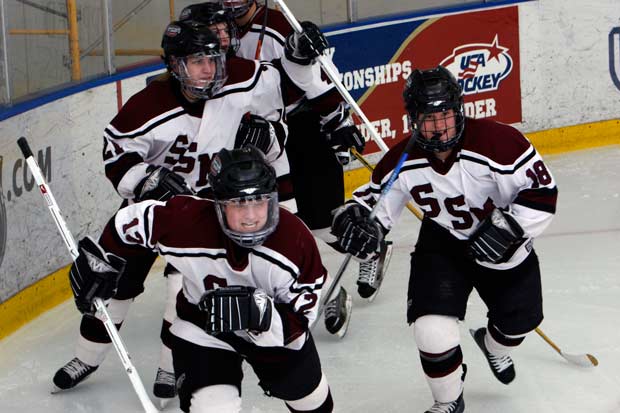 Jocelyne Lamoureux (front) celebrates after a Shattuck-St. Mary's goal, while twin sister Jocelyne (21) trails. The two took their high school to three national titles and will battle for Team USA in the Sochi Olympics.