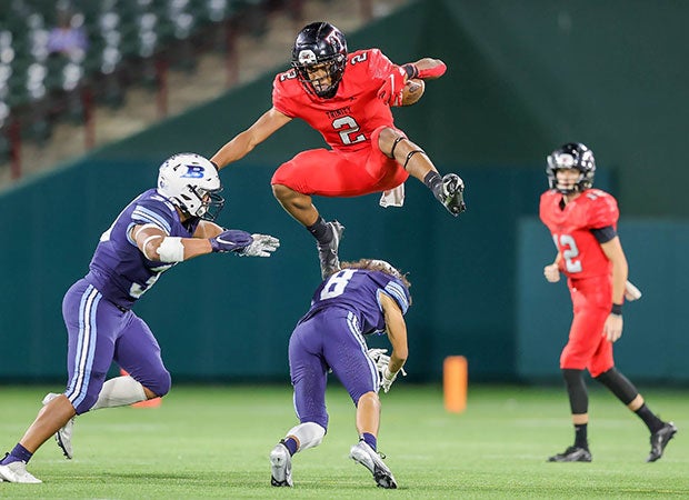 Euless Trinity (Texas) running back Ollie Gordon hurdles a Bell defender at Choctaw Stadium in September.