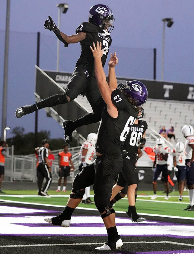 College Station (Texas) receiver Traylen Suel leaps while celebrating a touchdown with a teammate in September.