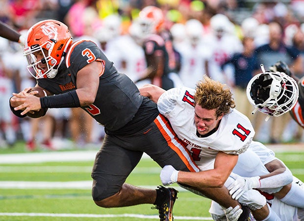 Milton (Ga.) linebacker Owen Pauley loses his helmet while bringing down North Cobb's Malachi Singleton in August.