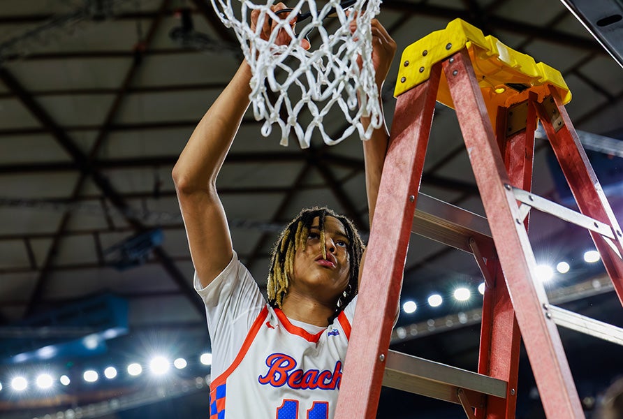 Freshman J.J. Crawford cuts down the nets at the Tacoma Center after leading Rainier Beach with 20 points against Lincoln in the Washington 3A state championship Saturday. (PHOTO: Jason Wang)