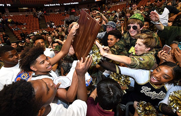 Ethan Thompson celebrates by sharing the championship plaque with Bishop Montgomery fans.