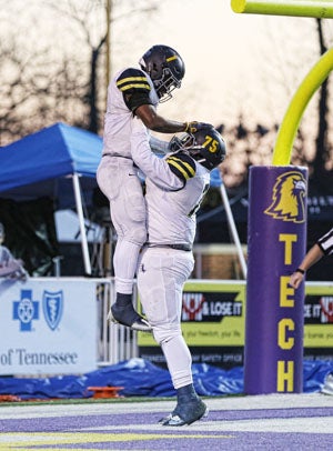 Eric Gray hoisted by teammate.