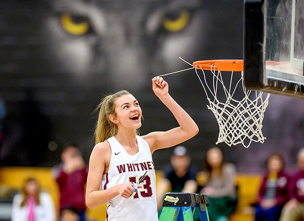 The Whitney (Calif.) mascot watches freshman Sophie Railsback cut a piece of the net after the school's first league championship in girls basketball.