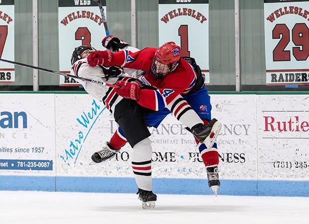 Natick's (Mass.) David Mega (right) lays a big hit on Wellesley's Liam Jenson.