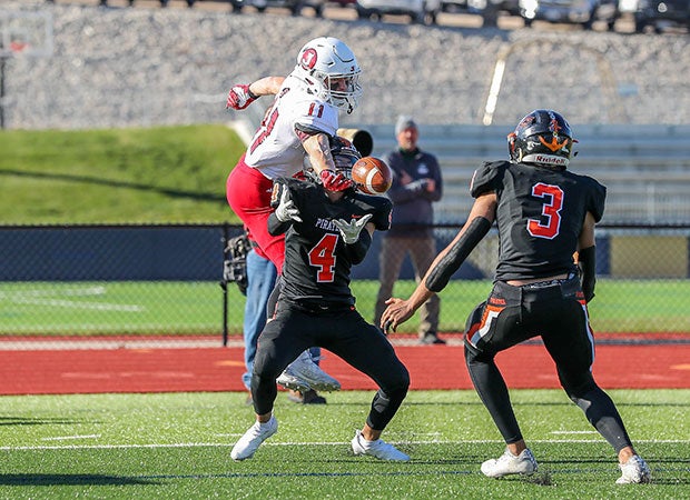 Jackson (Mo.) receiver Kannen Turley reaches over Platte County defensive back Garrett Smith to break up an interception attempt in the MSHSAA Class 5 state championship game.