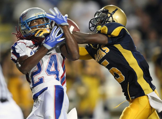 Byrnes wide receiver Isaiah King tries to haul in a pass under heavy duress from Keione Payne of St. Thomas Aquinas. 