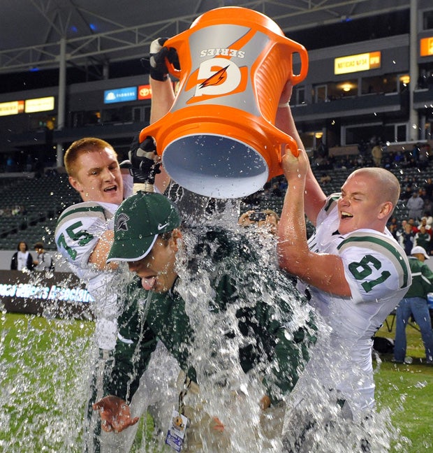New De La Salle head coach Justin Alumbaugh is doused after last year's CIF Open Division title win over Centennial (Corona), the Spartans' fourth straight state Open crown and fifth overall. 