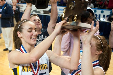 Nicole Boudreau, left, and a teammate hoist their third consecutive MIAA Division 1 trophy.