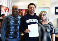 Nigel with his letter of intent
to Washington flanked by his
mother and father.
