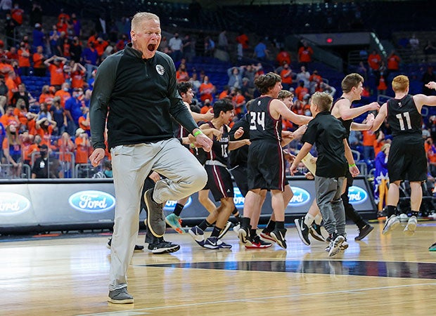 Texline (Texas) head coach Coby Beckner celebrates on the court with his players (background) after winning the  UIL Class 1A state championship game at the Alamodome in San Antonio.  