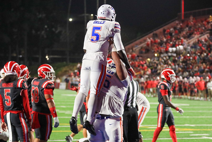 Corey Hinton Jr. gets a lift after his second touchdown of the night. (PHOTO: Rene Morales)