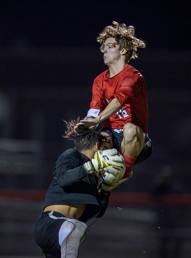 Gulf's goalkeeper makes an aggressive save with Dunedin player closing fast. (Photo: Chris Copek)