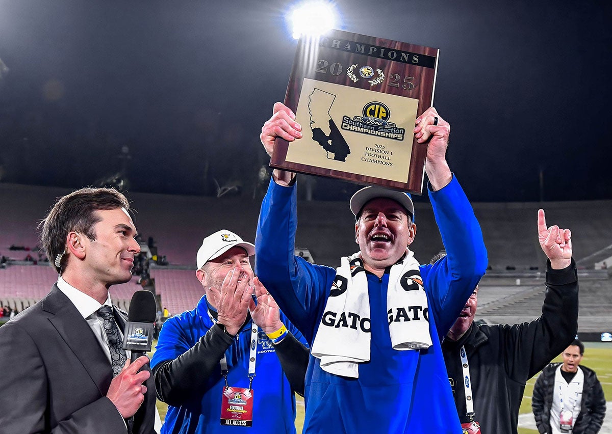 Santa Margarita head coach Carson Palmer holds up the Southern Section Division 1 championship plaque last month. Now the former NFL quarterback has his team's sights set on a state championship this week. (PHOTO: Louis Lopez)