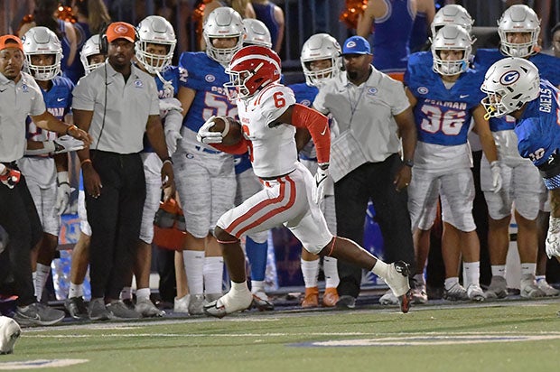 Mater Dei's Nathaniel Frazier picks up yardage while racing toward the Bishop Gorman sideline Friday night.