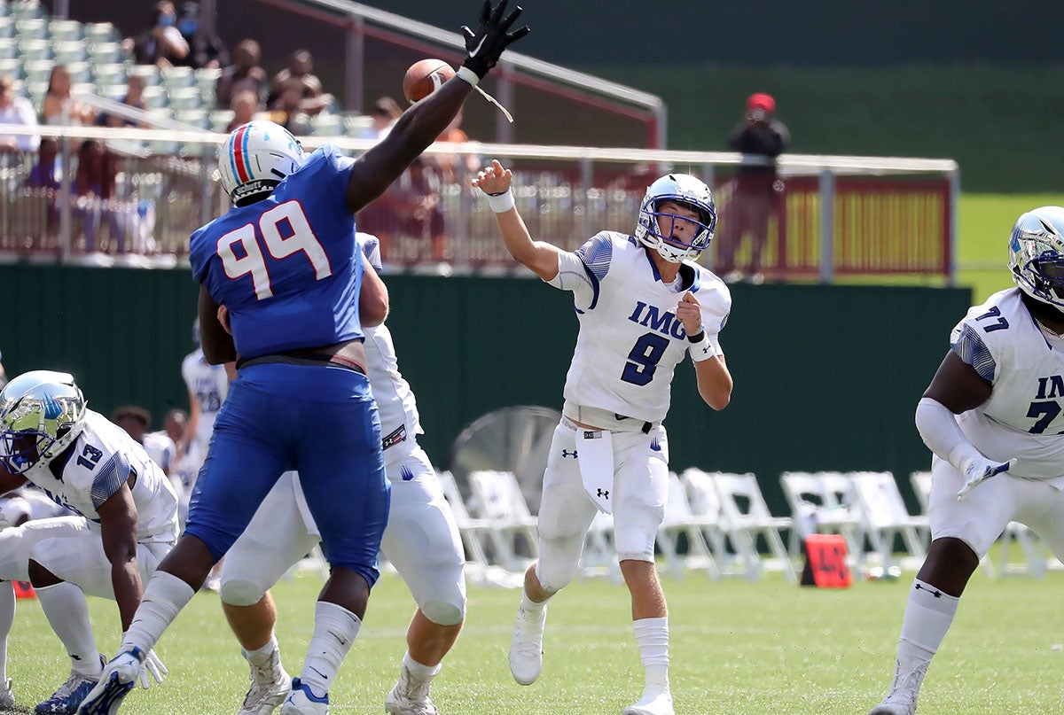 J.J. McCarthy of IMG Academy throws a pass in 2020 at Choctaw Stadium, the former home of the Texas Rangers. Behind him is Green's Hill, the grass batter's eye just beyond the center field fence. (FILE PHOTO: Robbie Rakestraw) 