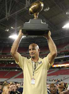 Desert Vista coach Dan Hinds raises
trophy following his team's sloppy
but thorough 20-10 win over Palo 
Verde in the 7th Solleberger Classic
at University of Phoenix Stadium. 