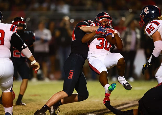Centennial running back Owen Reynoso is taken off his feet by a Liberty defender. (Photo: Kevin French)