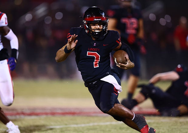 Senior quarterback Navi Bruzon of Liberty scrambles for yardage in the first half. (Photo: Kevin French)