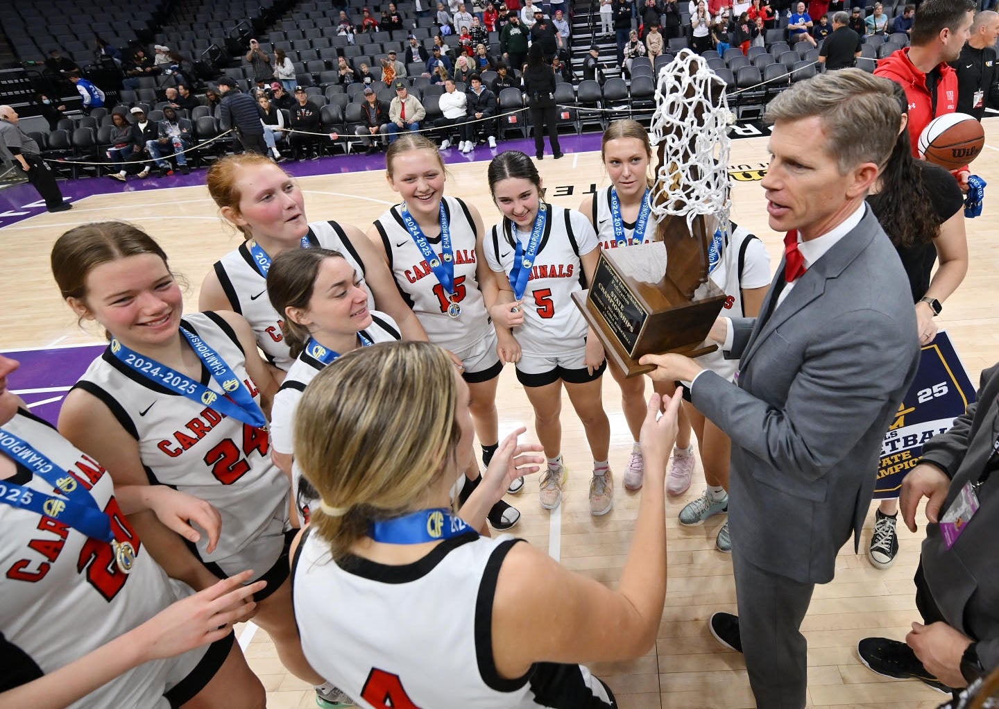 Woodland Christian head coach Shiloh Sorbello celebrates the school's first girls basketbal state title with his team after the Cardinals' 47-41 Division V win Friday over Rosamond at Golden 1 Center in Sacramento. (PHOTO: David Steutel)
