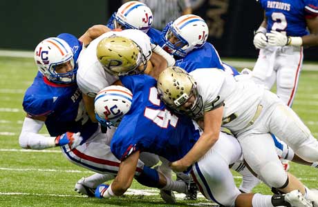 The Curtis defense swarms a Plant player while making a tackle.