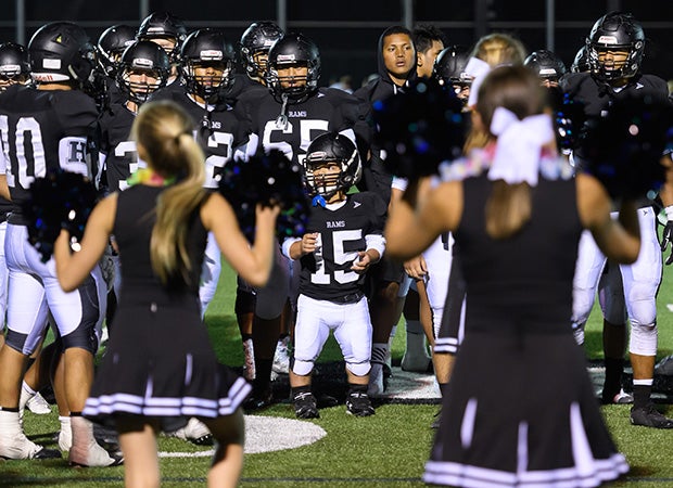 Schreiter gathers with teammates while cheerleaders and fans sing the school's fight song following the game.