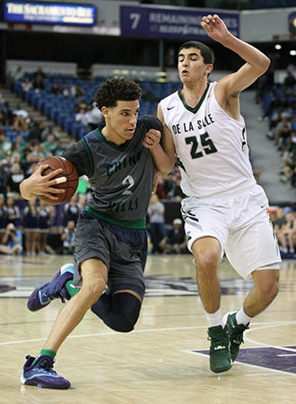 Chino Hills guard Lonzo Ball drives to the basket while
closely guarded by De La Salle's Jordon Ratinho.