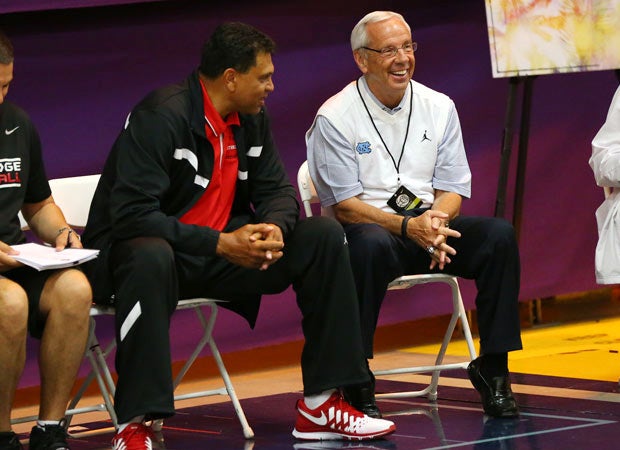 Former NBA coach and current Cal State Northridge coach Reggie Theus (left) talks to North Carolina's Roy Williams.