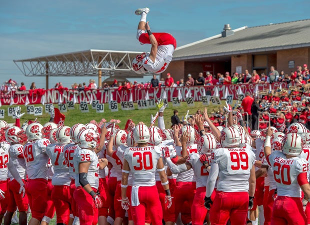 Katy (Texas) players toss teammate Sam Wells into the air before the start of their game against Cinco Ranch.