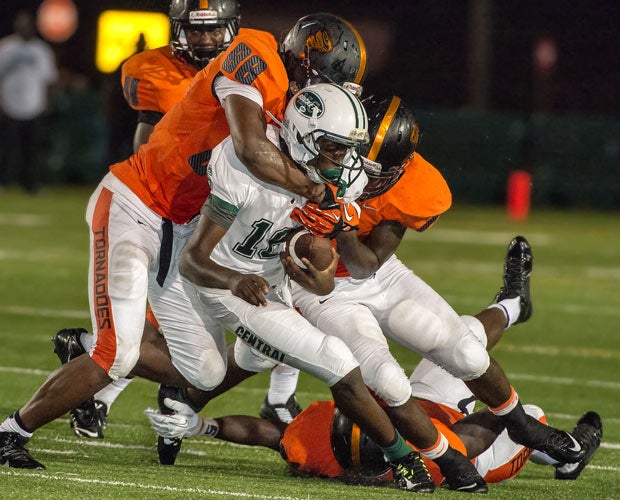 Three Brooker T. Washington defenders bring down a Central player on Friday night in Miami.