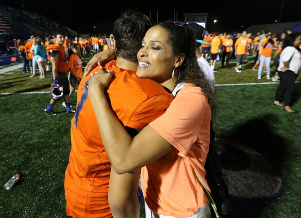 Rasheda Ali-Walsh, the daughter of Muhammad Ali, gives her son, Biaggio Walsh, a congratulatory hug following the game. Walsh scored the game's first touchdown on a 1-yard run.