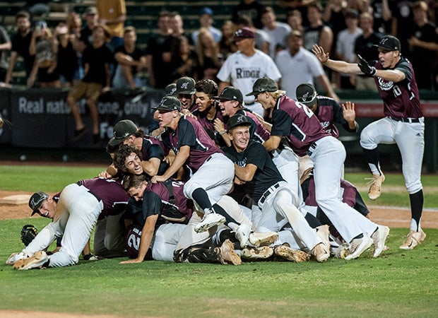 Hamilton (Ariz.) players pile on while celebrating their victory over Mountain Ridge in the AIA Division 1 state championship game at Tempe Diablo Stadium.