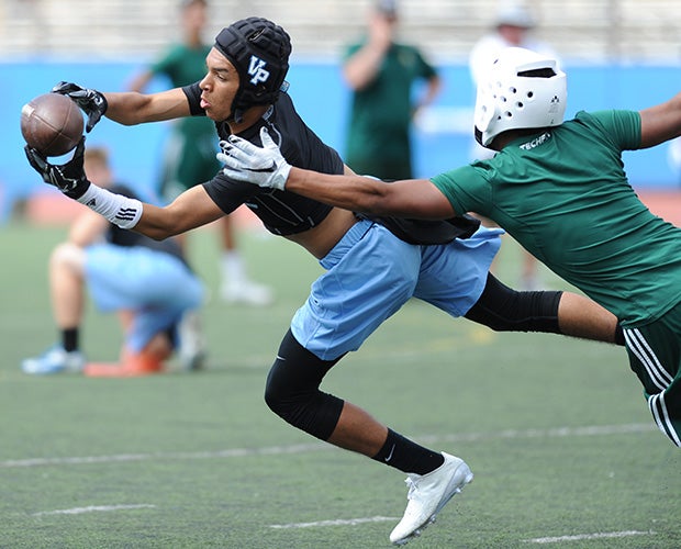 A Villa Park (Calif.) receiver stretches to make a catch in front of a defender during the Air Strike Elite Passing Tournament in Southern California.