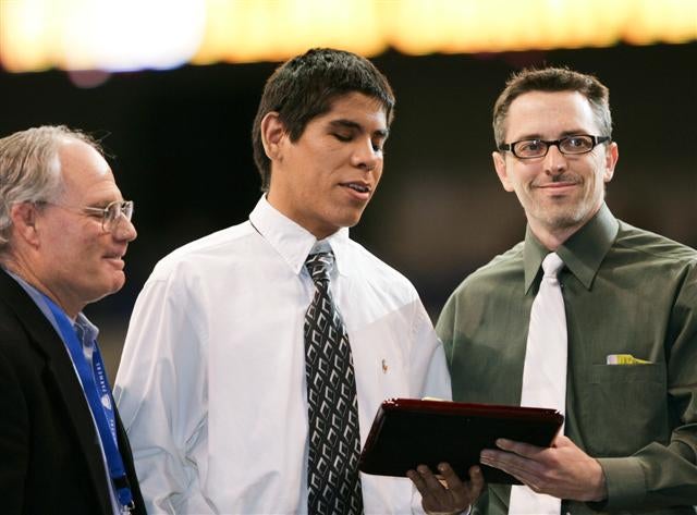 James Magana (middle) accepts award from coach Daren de Heras (right) in Bakersfield last month.