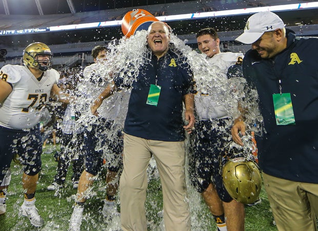 Aquinas assistant head coach Jay Connolly receives a water dousing.