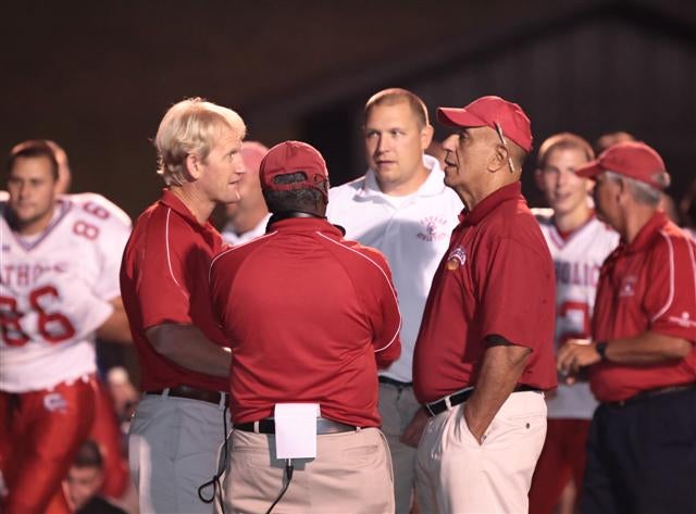 Charlotte Catholic's Jim Oddo (right) talks with his staff prior to a game against North Gaston last season.