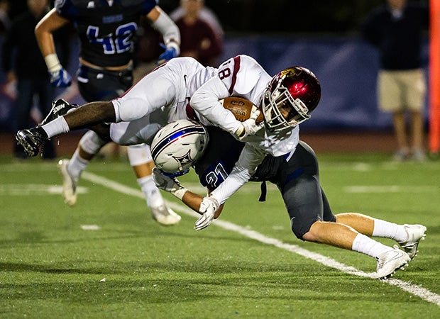 Lassiter (Ga.) running back Nnamdi Orjioke is sent flying on a tackle by Walton safety Drew Michalek.     