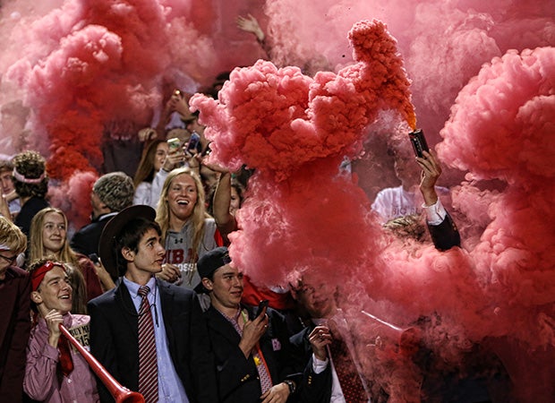 Montgomery Bell Academy (Tenn.) students release colored smoke in the stands while cheering on "Big Red" during a football game against Brentwood Academy.