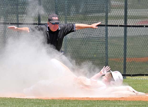 Keaton Malcolm of Ponder (Texas) emerges from a chalk cloud safe at third base after getting caught in a rundown during a UIL 2A Region 2 Bi-District state playoff game against Whitney in May.