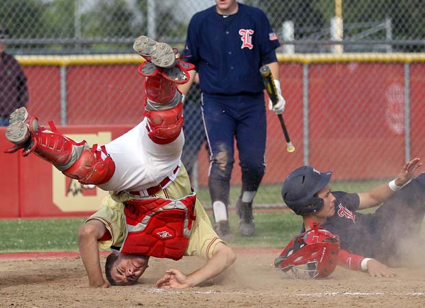Centennial (Calif.) catcher Adam Hightower lands on his head after a collision at home plate during a game against visiting Liberty in May.