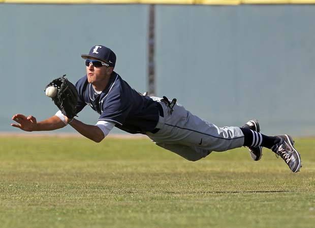 A Loyola (Calif.) outfielder makes a diving catch during a game against host Crespi in April.